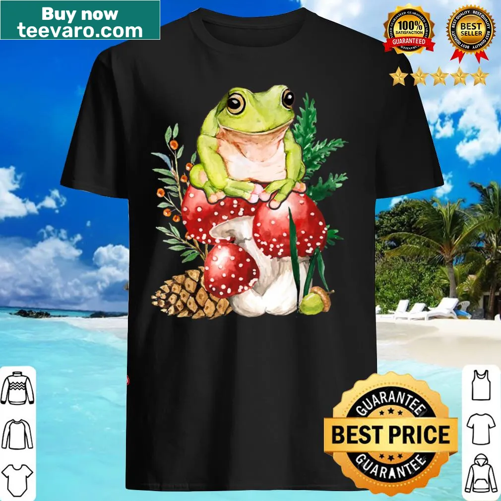 Illustrated T-shirt featuring cute frogs and mushrooms in a cottagecore style.