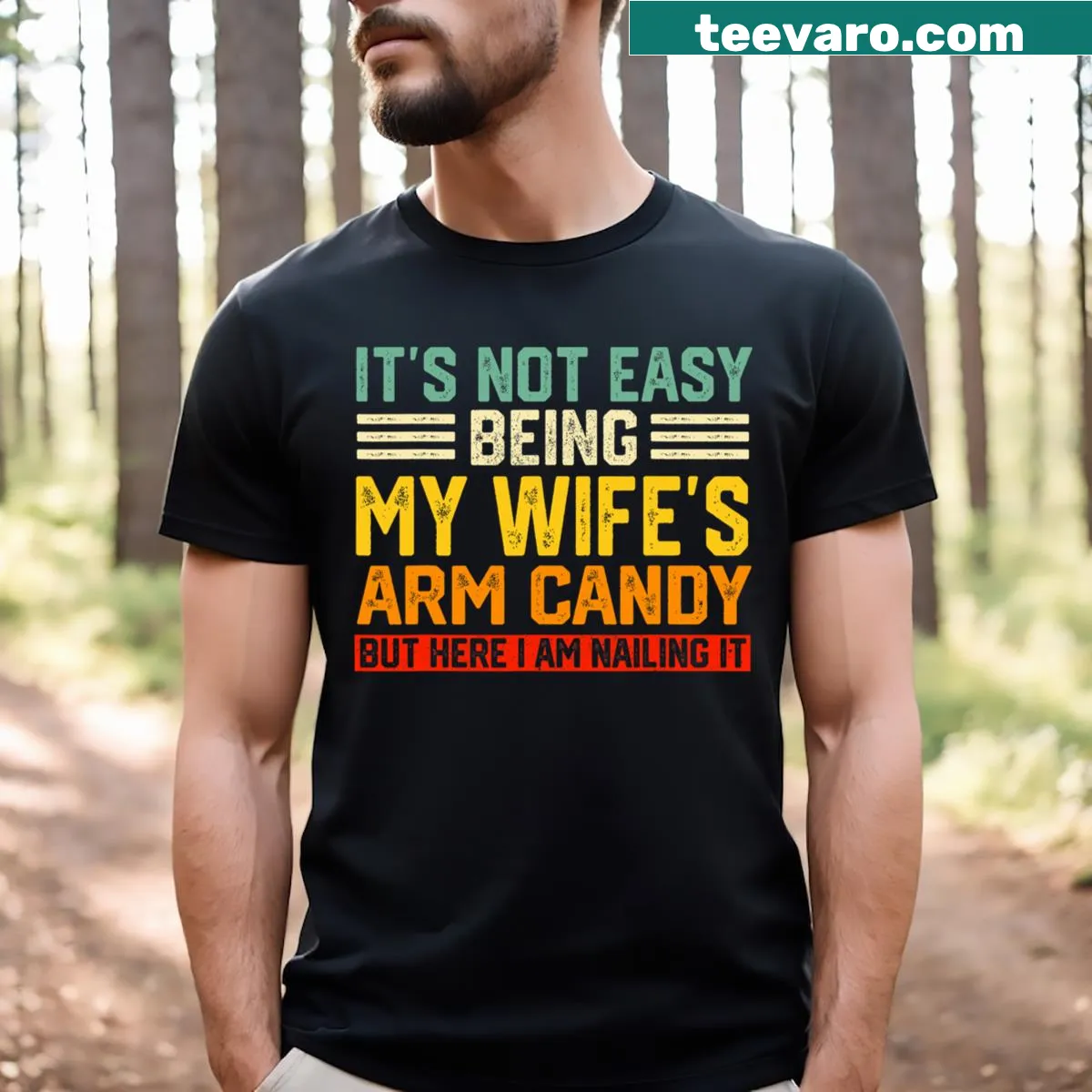 Funny t-shirt for husbands with the phrase 'It’s Not Easy Being My Wife’s Arm Candy.' — on a men's t-shirt