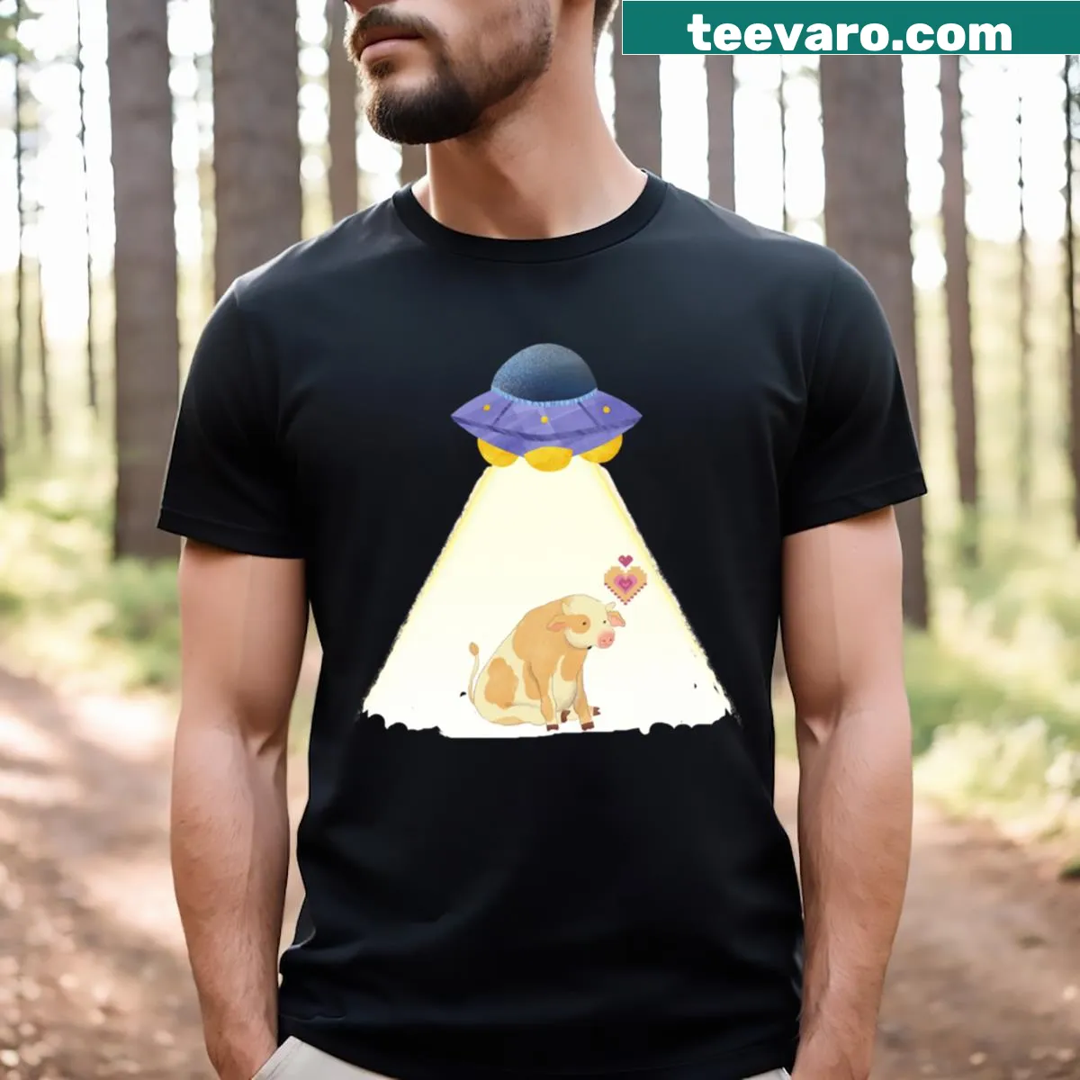 Humorous T-shirt depicting a cow being abducted by a UFO. — on a men's t-shirt
