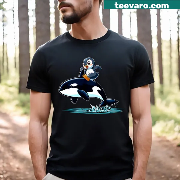 Cartoon graphic of a penguin riding an orca on kids T-shirt