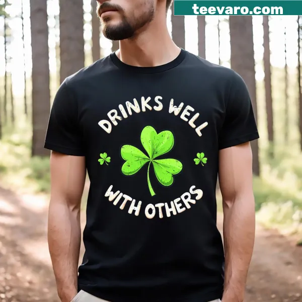 Funny beer-themed T-shirt with 'Drinks Well With Others' text for St. Patrick's Day
