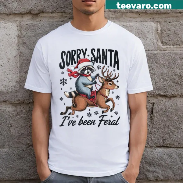 Funny holiday t-shirt with a raccoon and 'Sorry Santa I've Been Feral' text