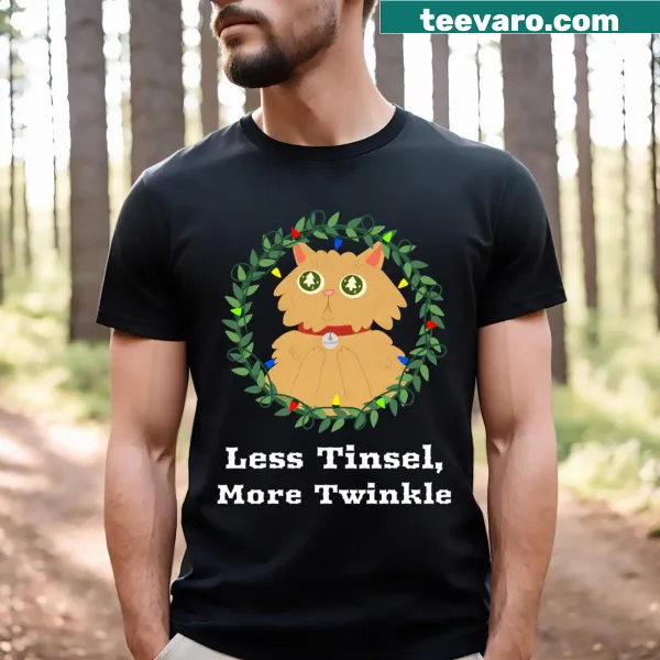 Playful Less Tinsel More Twinkle text on a festive T-shirt
