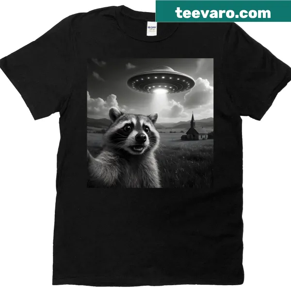 Funny t-shirt featuring a raccoon taking a selfie with a UFO