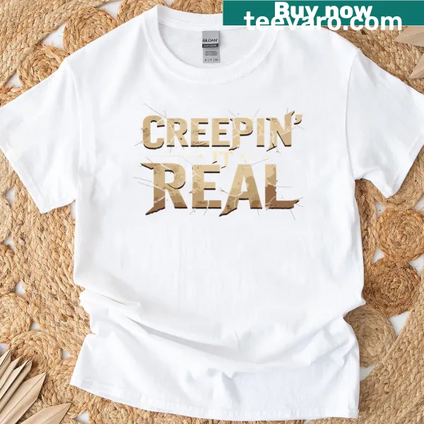 T-shirt featuring 'Creepin It Real' text in a playful typography style.
