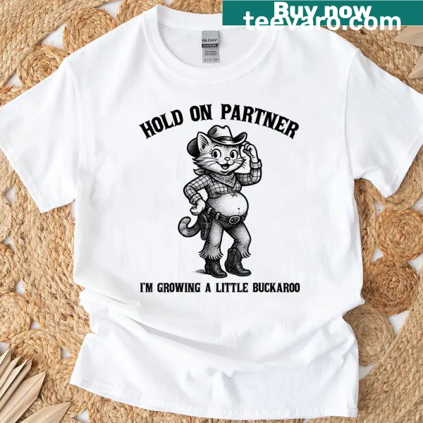 Funny pregnancy T-shirt with 'Hold On Partner, I'm Growing A Little Buckaroo' text.