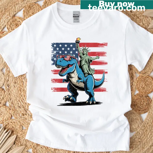 Toddler t-shirt featuring cartoon dinosaur as Statue of Liberty with USA flag