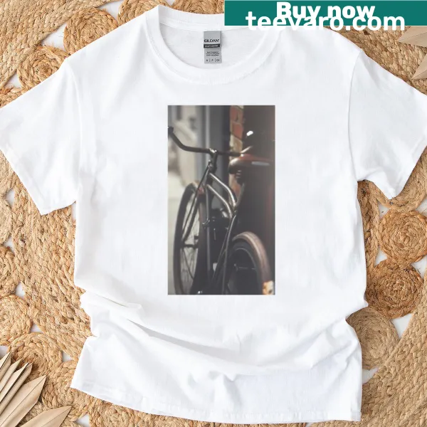 Illustration of a bicycle parked against a red brick wall on an oversized t-shirt.