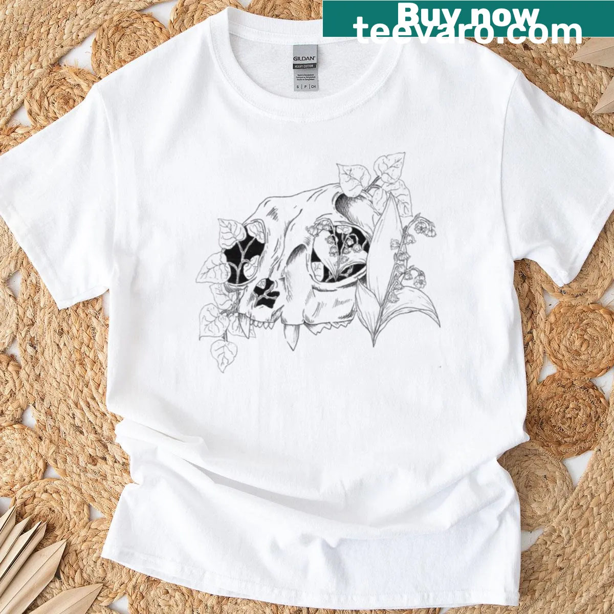 Cat skull illustration surrounded by lily of the valley flowers — on a men's t-shirt