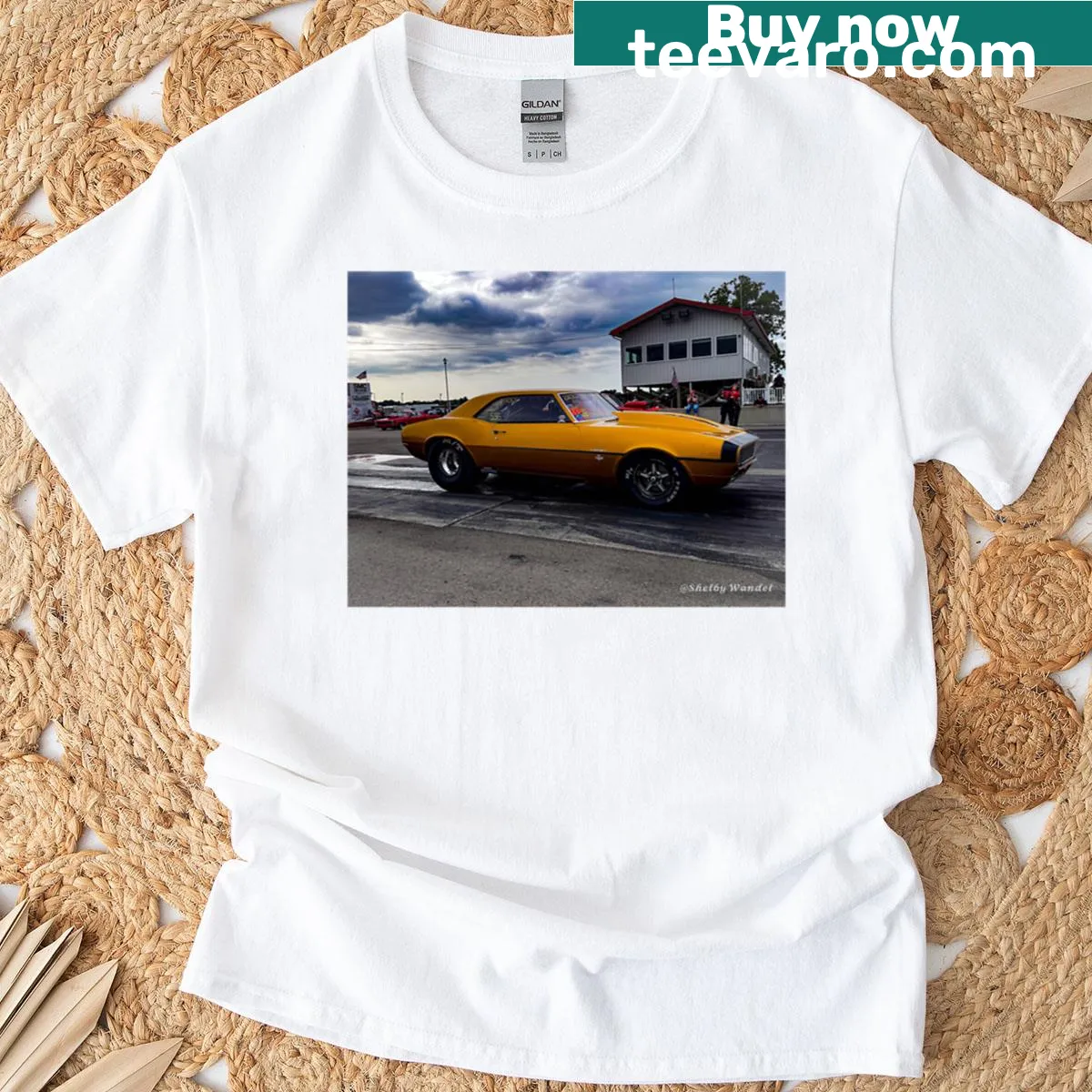 Gold oversized t-shirt with desert landscape illustration — on a men's t-shirt