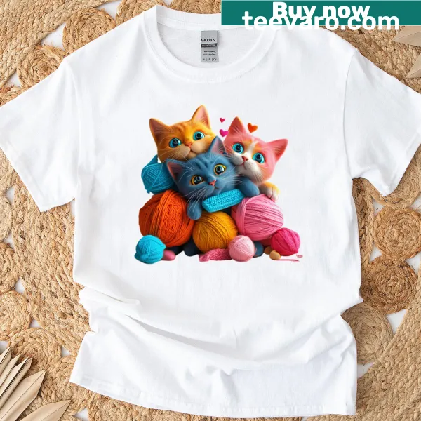 Three playful cats tangled in colorful yarn on T-shirt