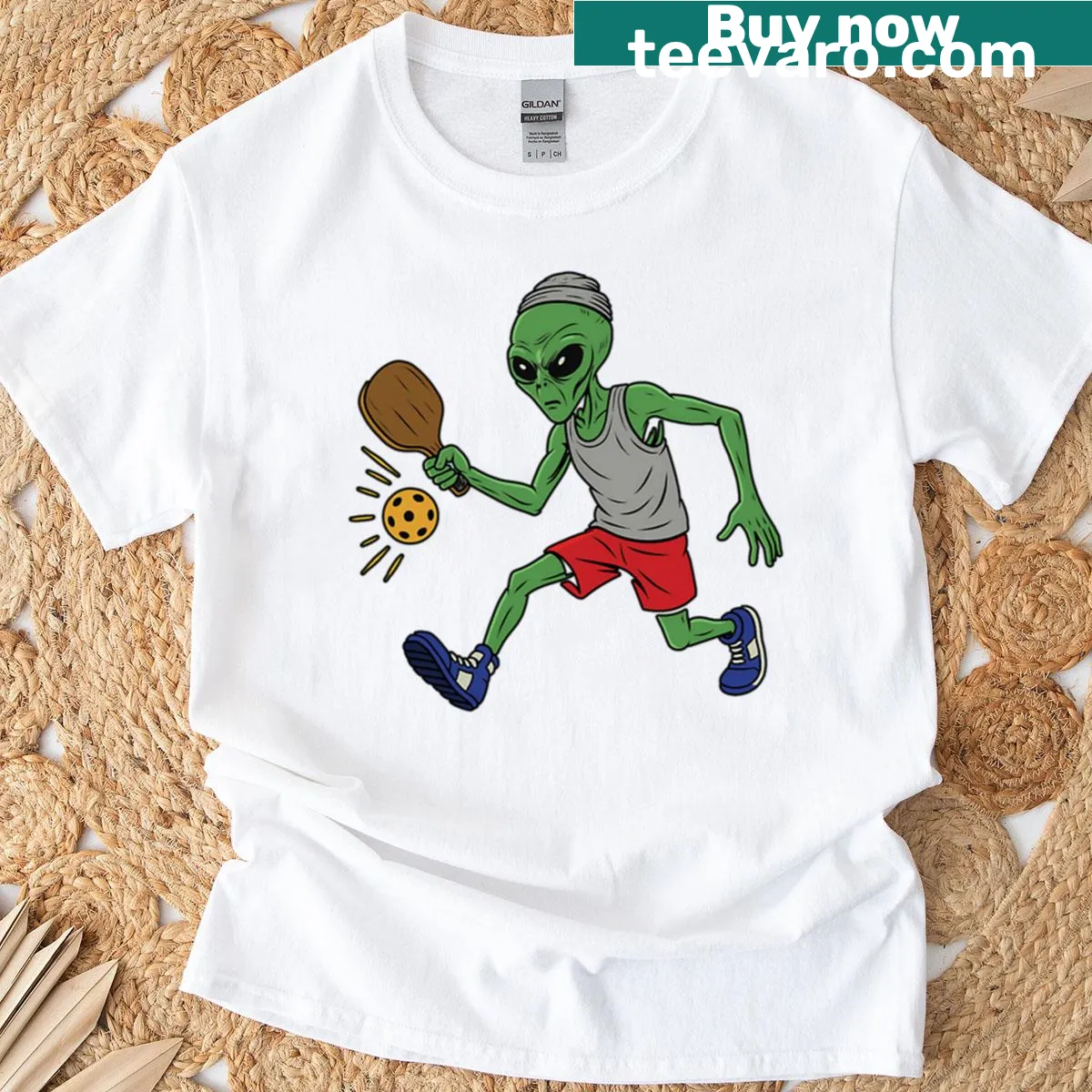 Cartoon alien playing pickleball on an oversized t-shirt — on a men's t-shirt