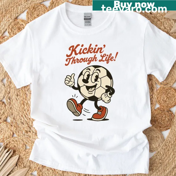 Cartoon T-shirt with soccer ball and the phrase 'Kickin Through Life'.