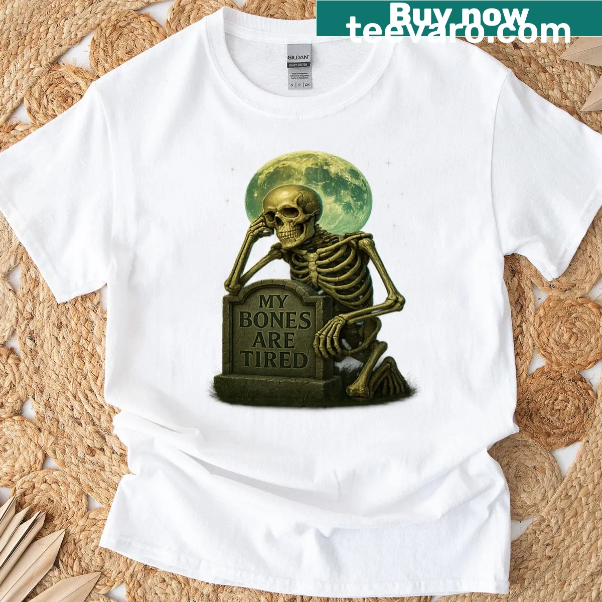Cartoon skeleton resting against tombstone t-shirt — on a men's t-shirt