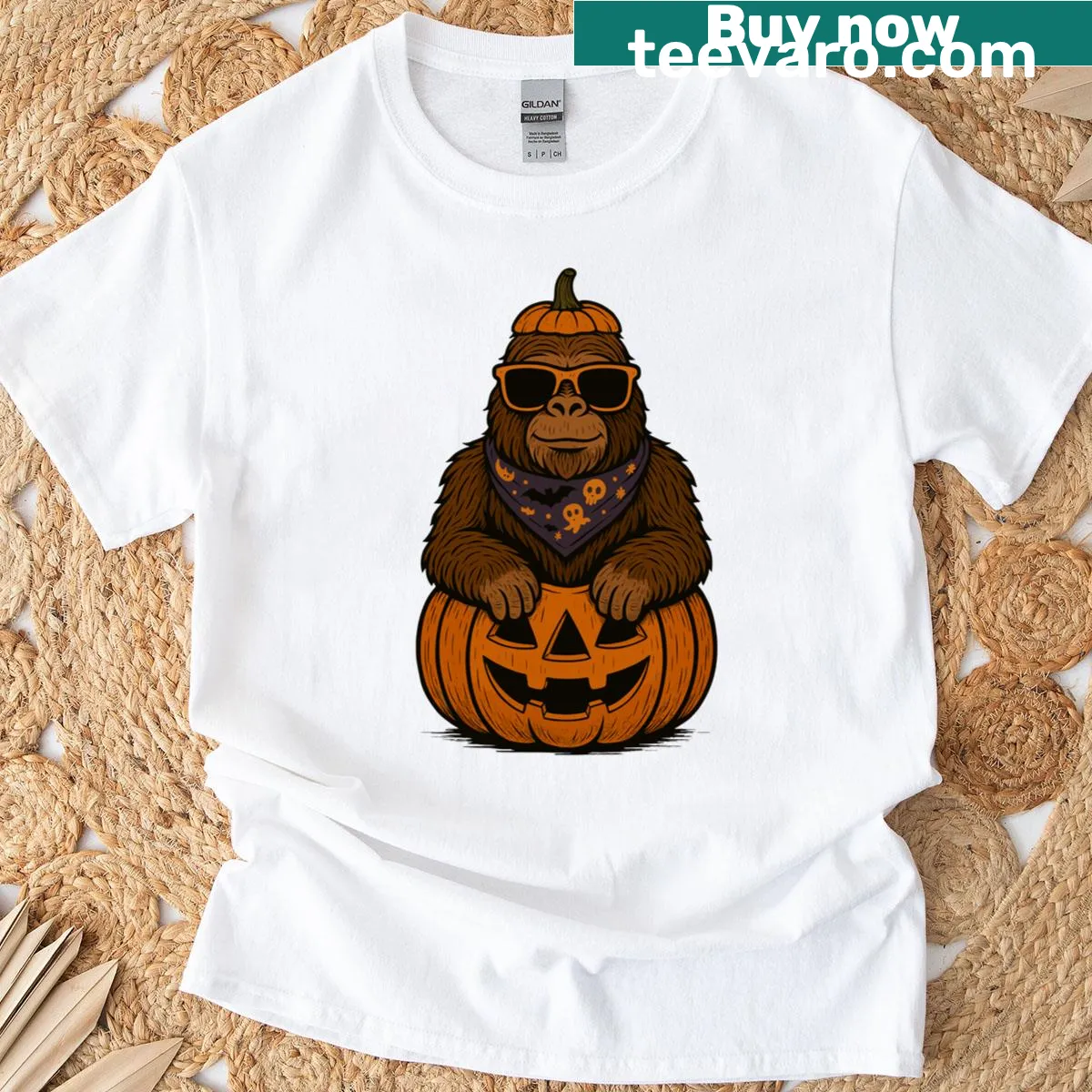 Illustration of Bigfoot carving a pumpkin for Halloween fun — on a men's t-shirt