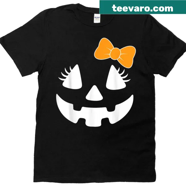 Cute pumpkin face with eyelashes and bow on a Halloween shirt.