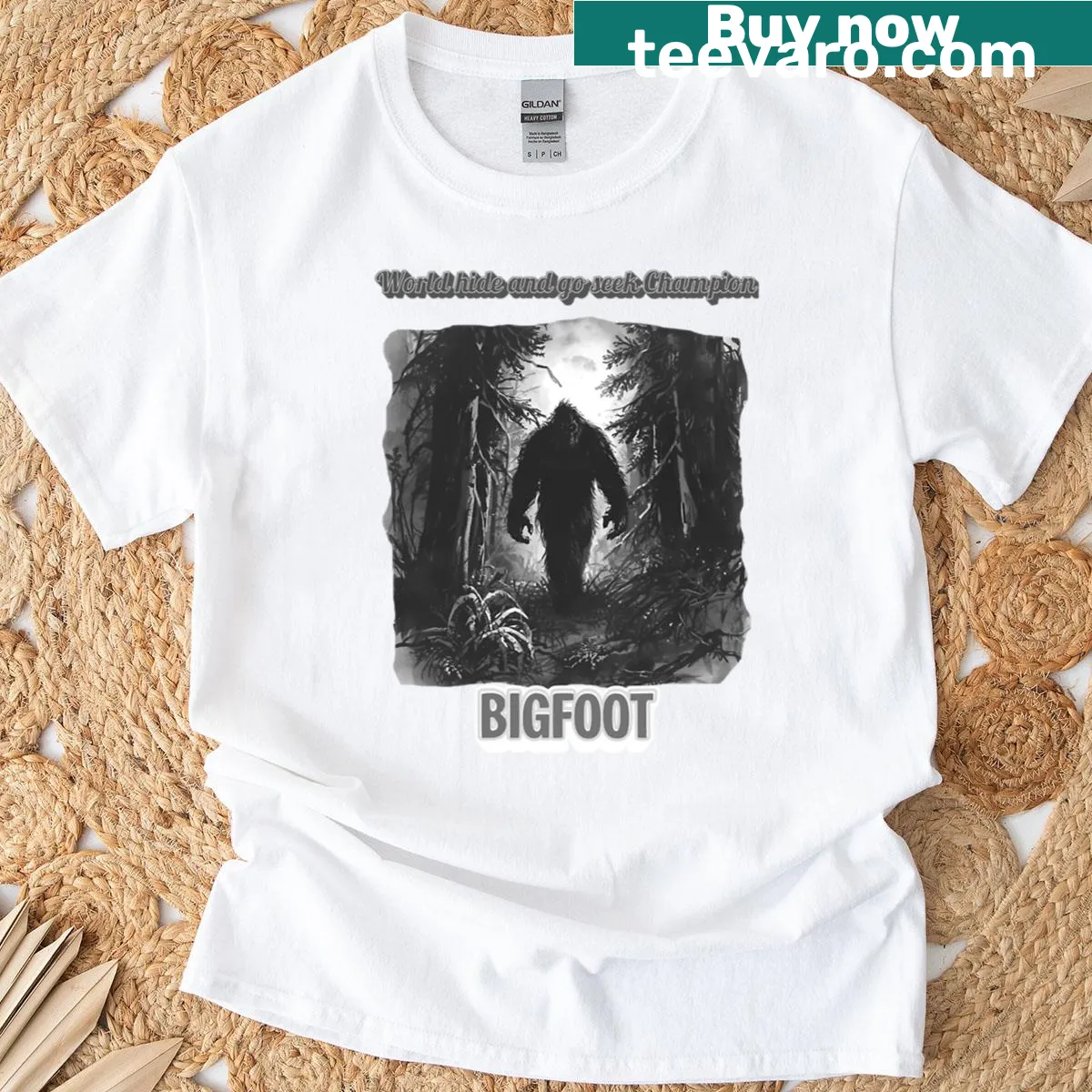 Cartoon Bigfoot with a playful hide-and-go-seek champion graphic — on a men's t-shirt