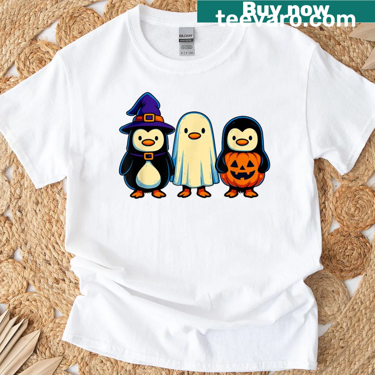 Cartoon graphic of a penguin witch with a ghost and pumpkin — on a men's t-shirt