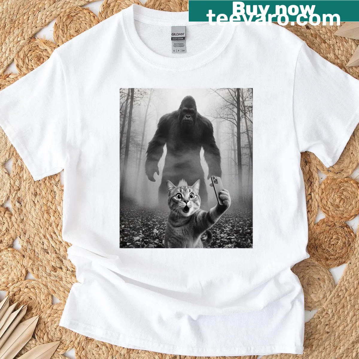 Illustration of a scared cat taking a selfie with a Sasquatch — on a men's t-shirt