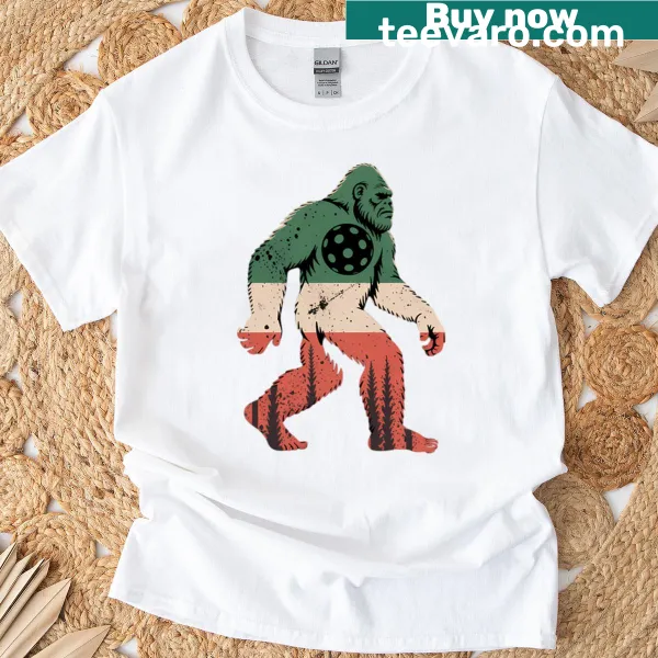 Bigfoot playing pickleball on a whimsical t-shirt