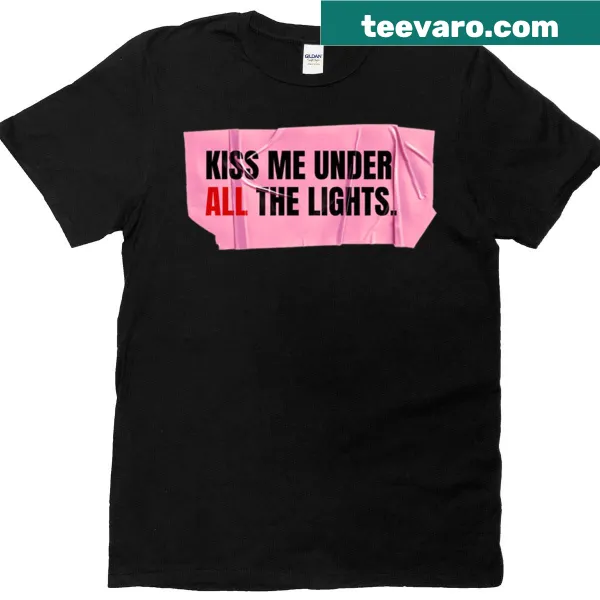Playful typography t-shirt with the phrase 'Kiss Me Under All The Lights' in pink tape aesthetic.