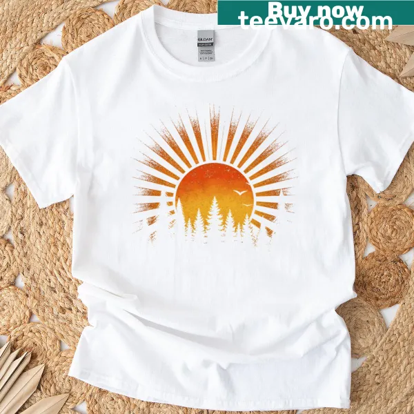 Illustrated forest and sunset graphic on a nature-themed T-shirt