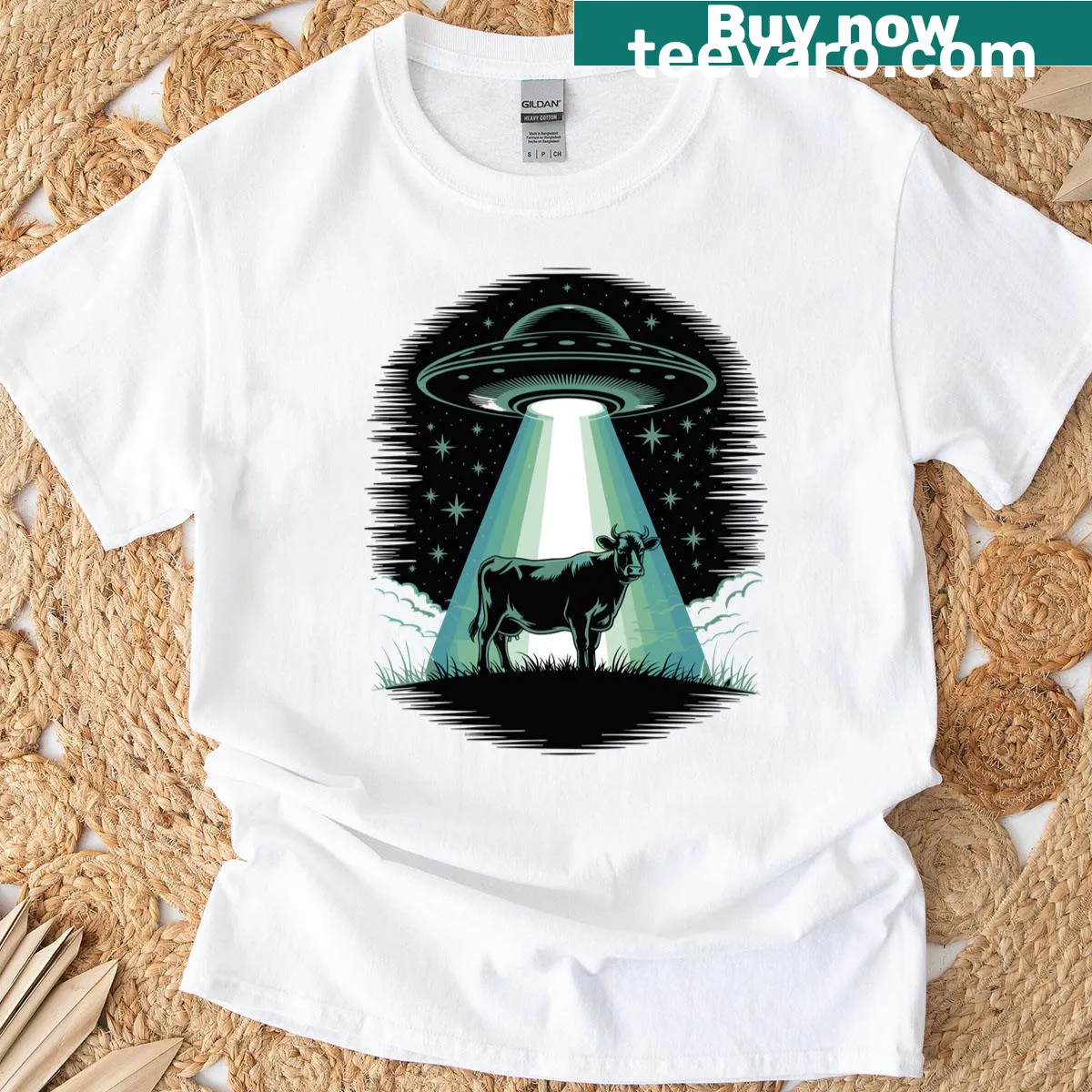 Cartoon cow under a UFO with stars, humorous alien-themed design — on a men's t-shirt