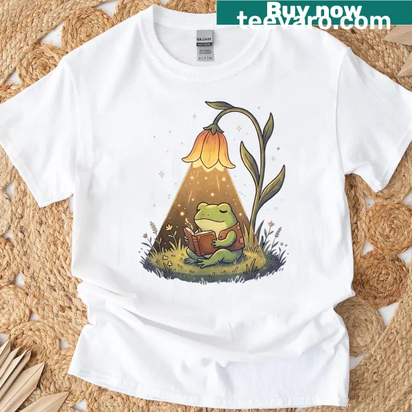 T-shirt featuring a frog reading a book in a charming design.